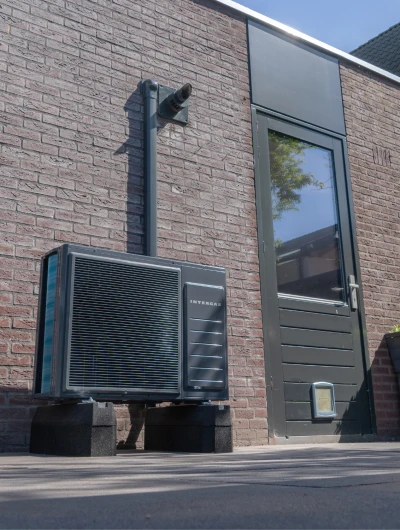 Warmtepomp unit tegen buitenkant van huis