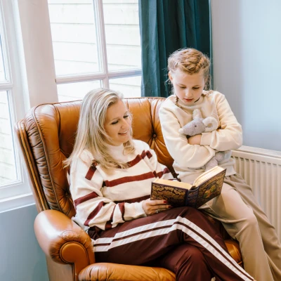 Op de foto leest een moeder haar dochter voor.