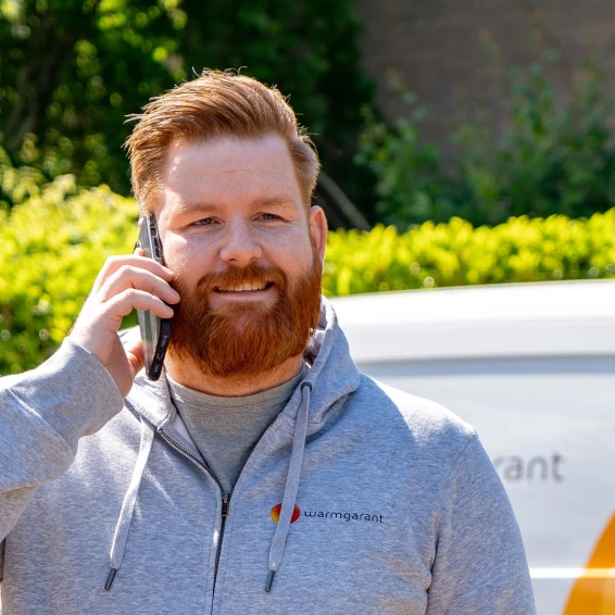 Installateur buiten aan de telefoon
