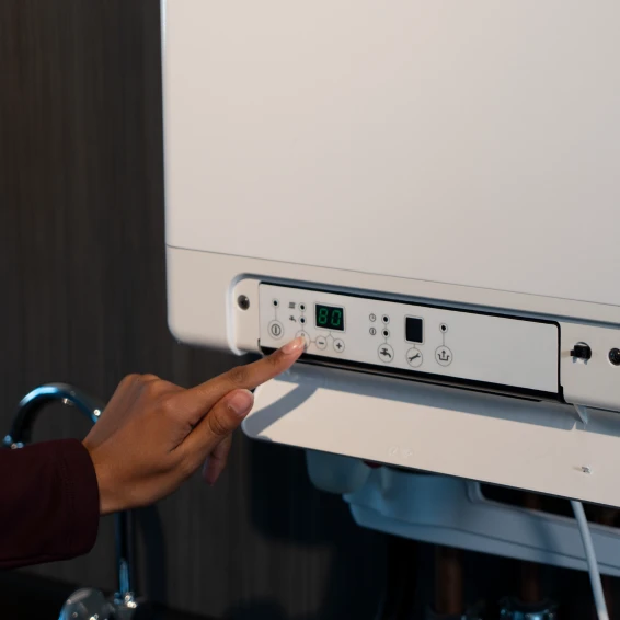 Hand die wijst naar het panel in de Intergas cv-ketel