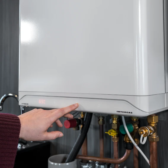 Hand die wijst naar een witte Intergas cv-ketel