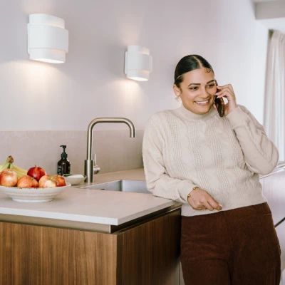 Vrouw aan het telefoneren in de keuken