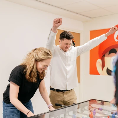 Twee collega's aan het tafelvoetballen bij Warmgarant